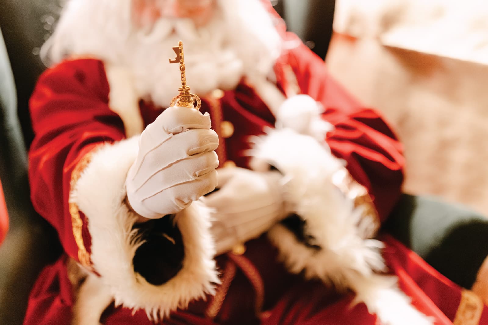 Santa holding out a golden Santa Key in his white-gloved hand