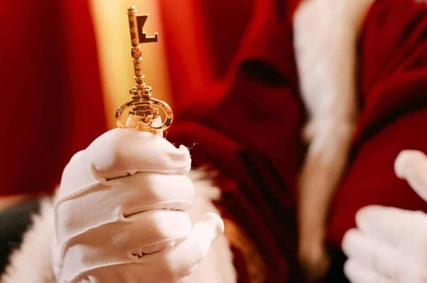 Father Christmas presenting the magical golden key given to Cheer Champions inside his Santa's Grotto at Bewl Water's Christmas experience in Kent.