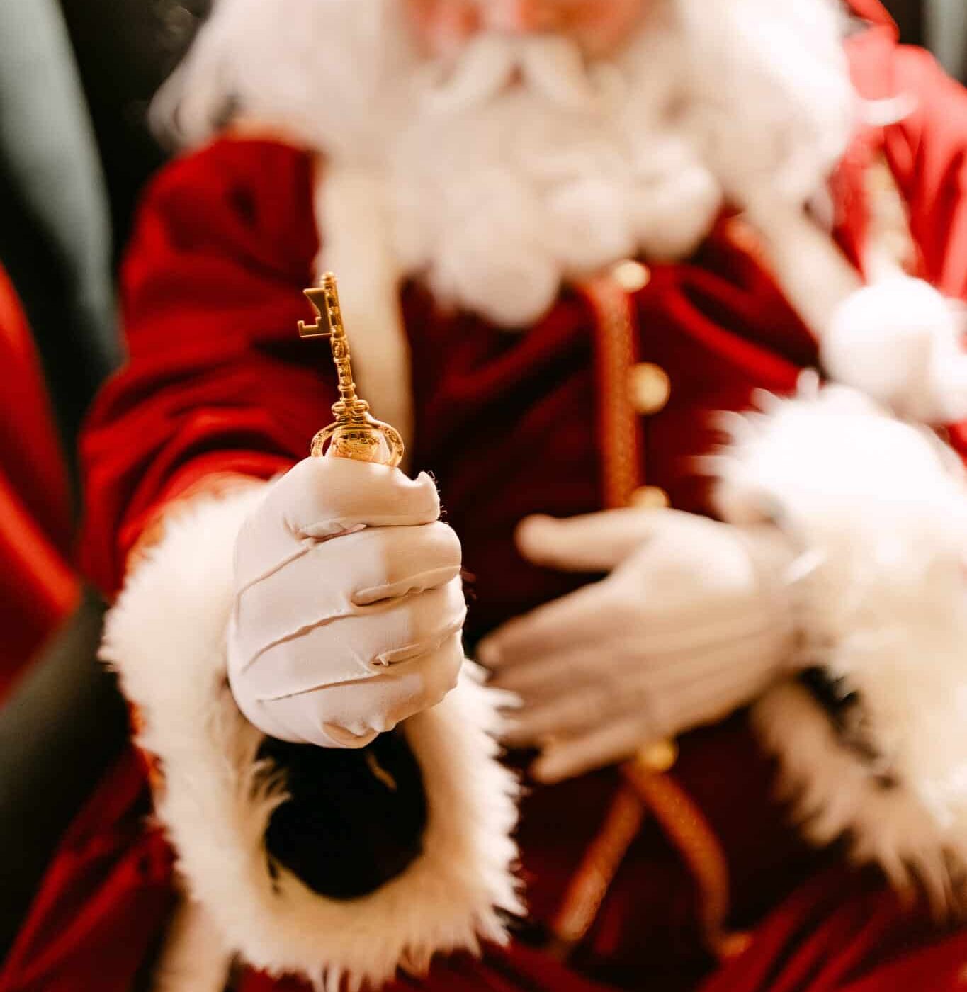 Father Christmas holding out the magical golden Christmas key at Christmas at Bewl Water, part of Kent’s immersive Santa’s Grotto and festive family experience.